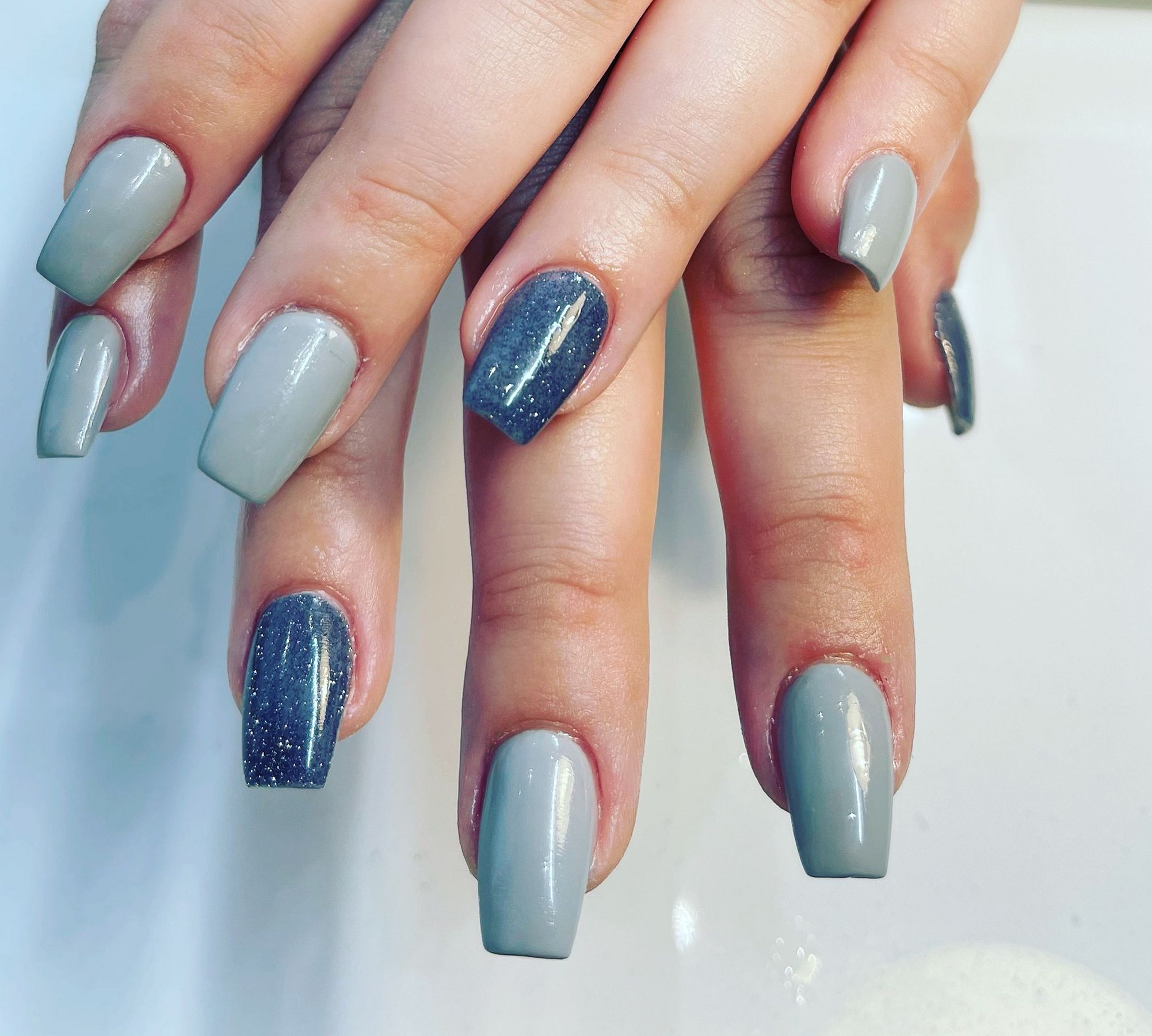 Grijsblauwe nagels met twee glitterblauwe accentnagels