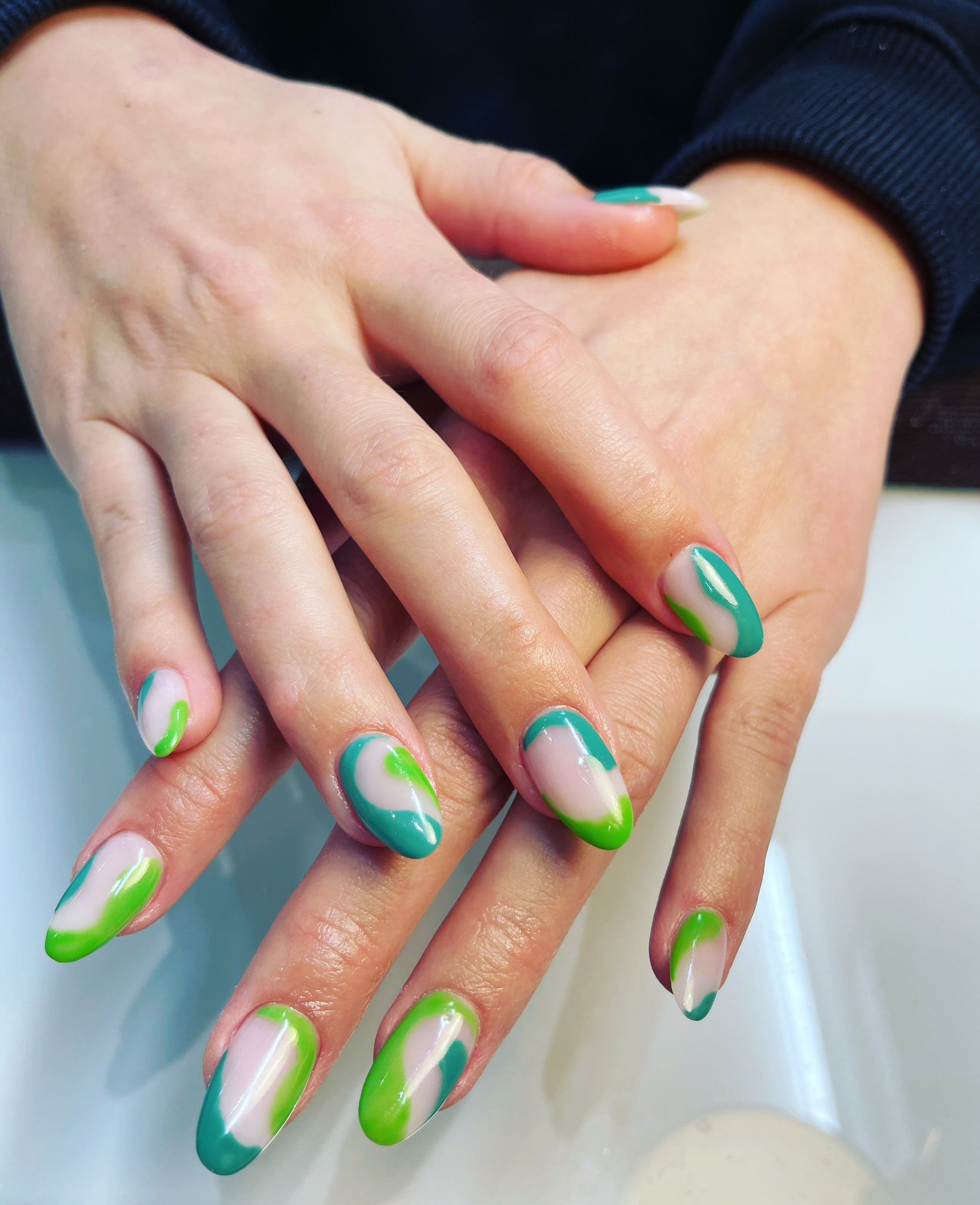 Nail art met groene en turquoise vegen op zachtroze nagels